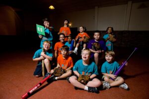 group of kids smiling with sports equipment