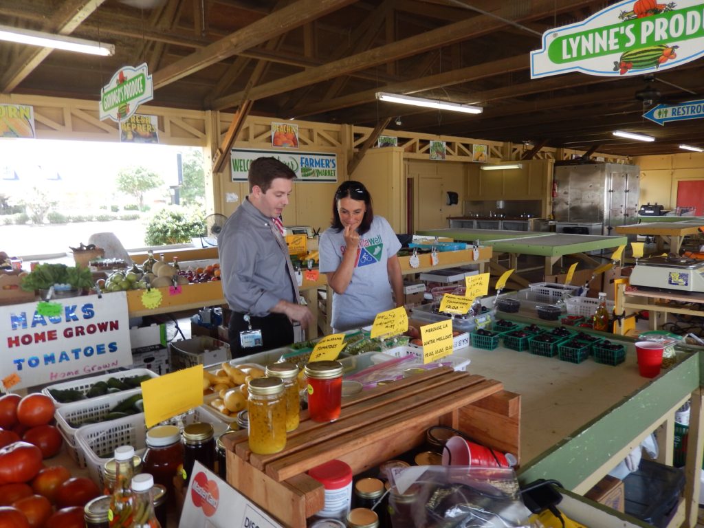 Tipton tours a revitalized farmers market with Ouachita Well Project Director Pamela Barton.